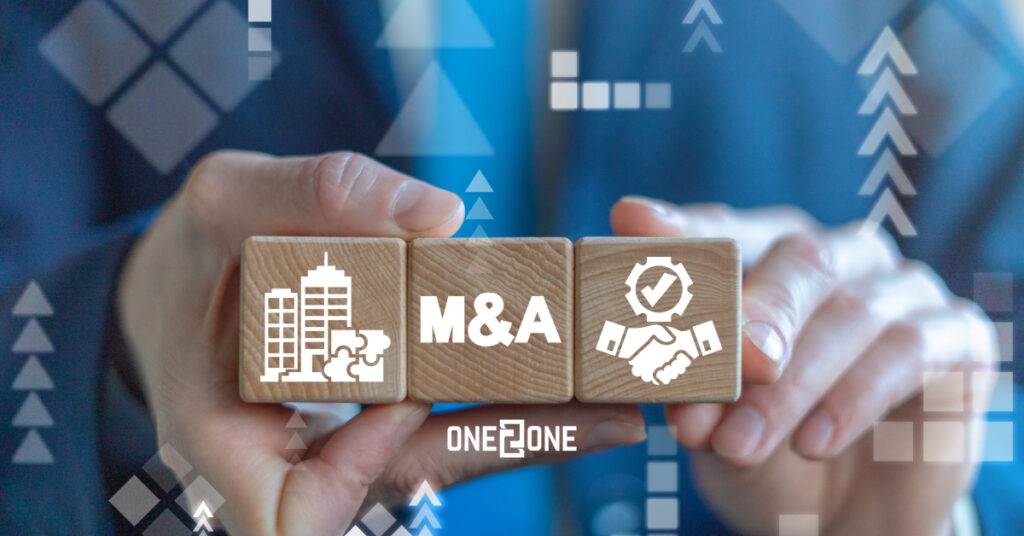 man holding wooden blocks that spell out mergers and acquisitions
