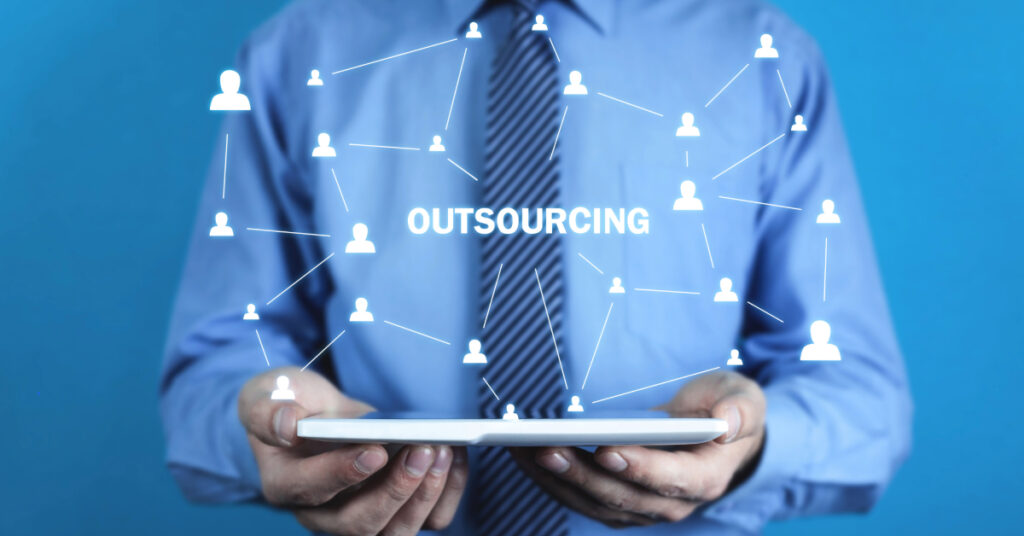 Business professional holding a tablet with a network graphic illustrating IT outsourcing for businesses