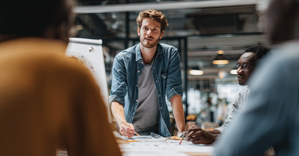 A small business team gathered around a table collaborating on a project, representing the importance of Zero Trust Security for Small Businesses.